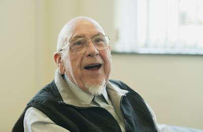 An older man smiling during a conversation